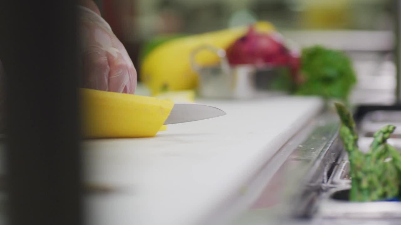 一个厨师在餐厅的厨房里切西葫芦。视频下载