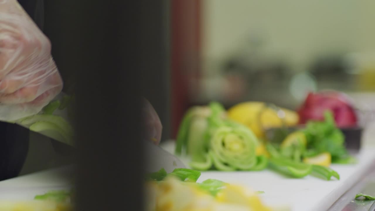 一个厨师在餐厅的厨房里切芹菜。视频下载