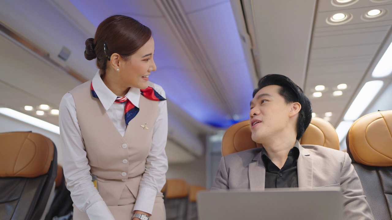 在飞机上，穿着空姐制服的机长或空姐与乘客交谈。视频素材