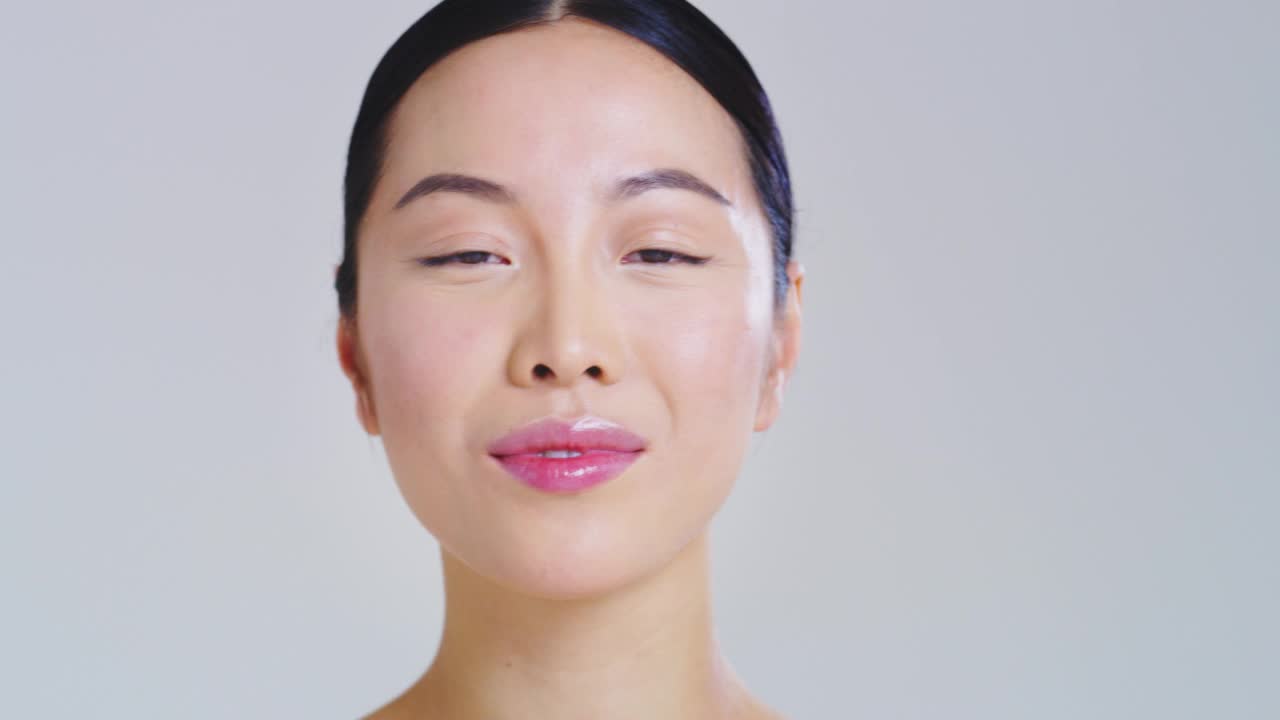亚洲女性漂亮的脸和完美的皮肤刚刚从杂质中清洁，用手轻轻触摸它，显示它是多么柔软和光滑。视频下载