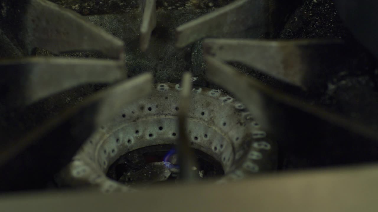 煤气炉上的燃烧器;煤气被点燃，蓝色的火焰爆发。视频下载