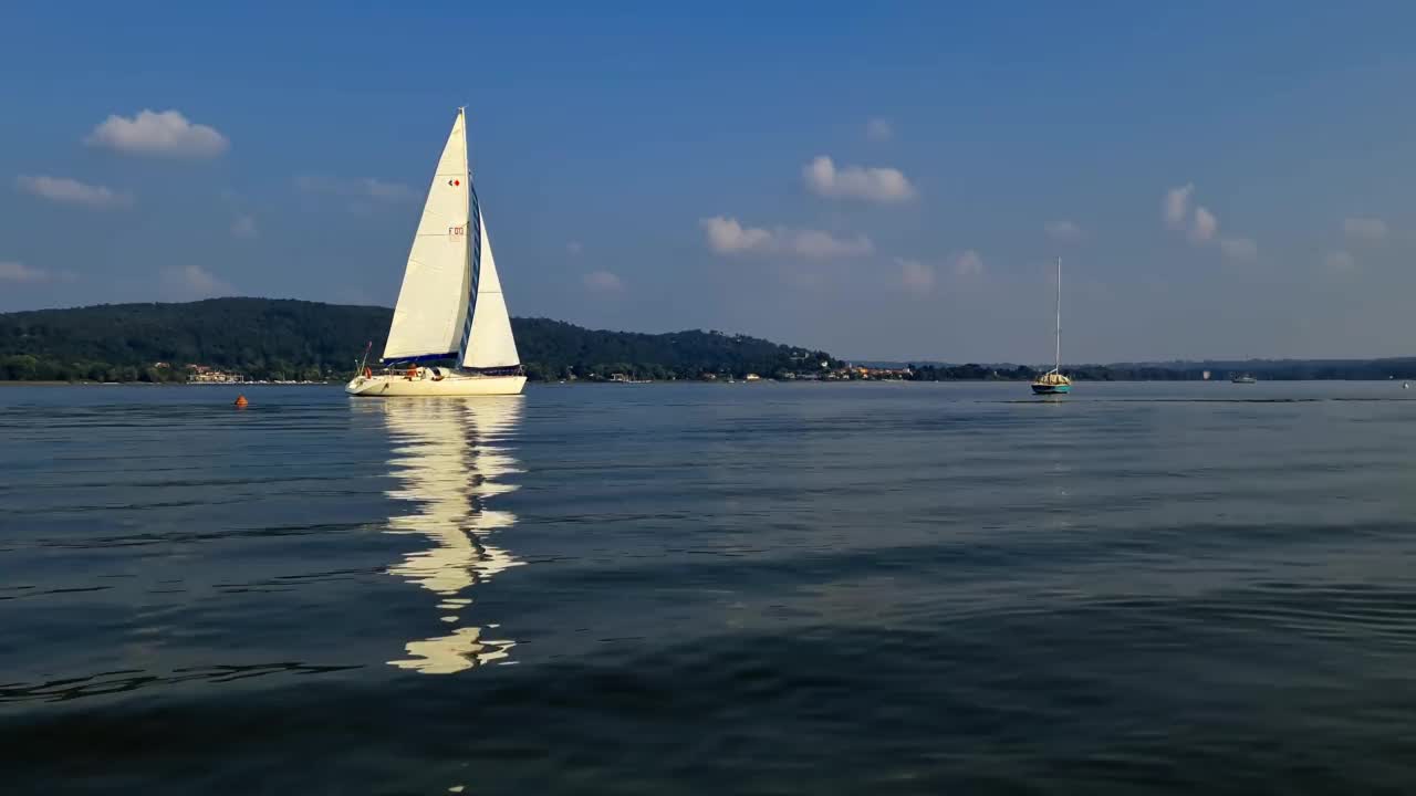 慢动作和极端低角度的看法小船航行在平静的开放的湖面马乔里湖在意大利视频素材