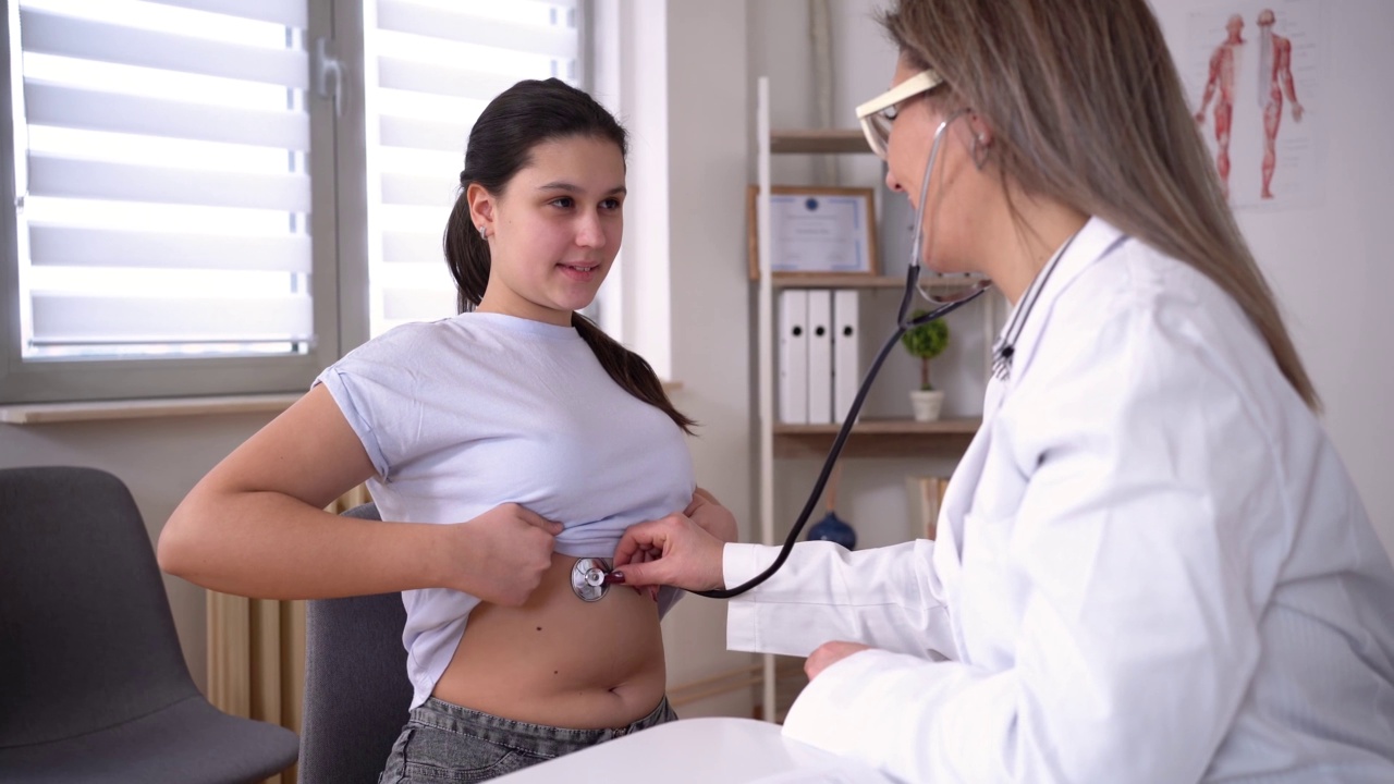 女医生检查青少年患者的心跳视频素材