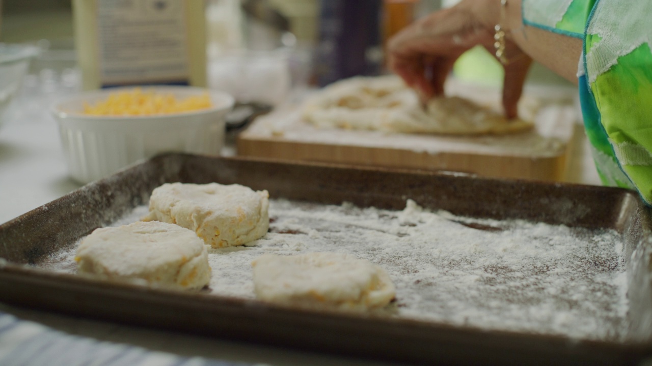 女人准备好饼干，把它们和面粉一起放在烤盘上。视频下载