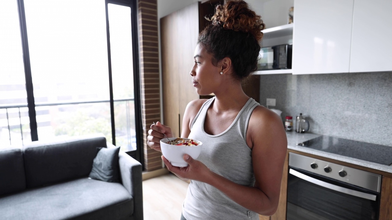 美丽的黑人年轻女子在晨练后享用美味的麦片视频下载