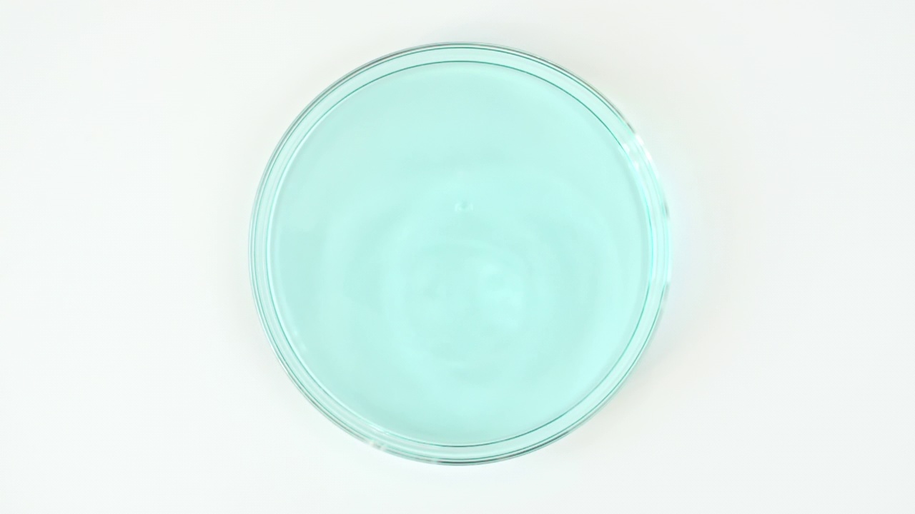 透明蓝色化妆液滴在玻璃碗的皮氏培养液。精华液，乳霜，透明尿酸。有机化妆品、药品。慢动作视频下载