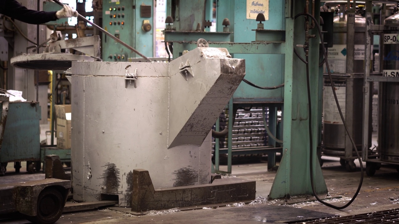 熔炼铝时，操作者努力工作，将熔化的金属从钢包上攻丝到保温炉压铸机上视频素材