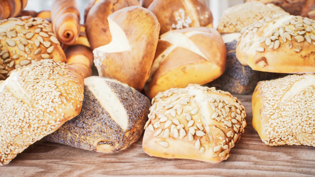 新鲜出炉的酥脆可口的小面包。特写丰满的面包，蛋糕和新鲜美味的面包。这个动画是关于美味食物和健康饮食的完美背景。视频素材