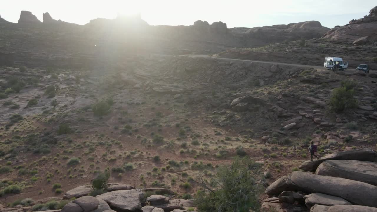 无人机漂亮的运动年轻女子徒步在广阔的沙漠景观摩押在犹他州西南部的沙漠视频素材