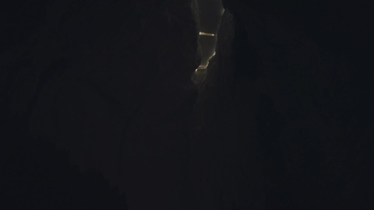 洞穴内部角度适中。看到大块的冰和雪堵塞了洞口在洞穴的顶部。看到大块的冰和登山者跌入洞穴。看攀登者吊在绳子上。底片剪。视频素材