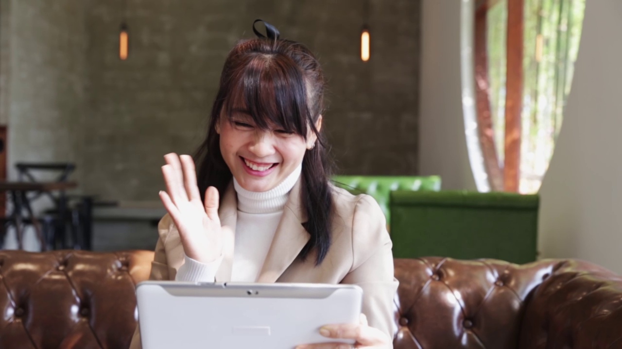 快乐亚洲女性谈视频会议通过电脑平板，商业女性使用平板电脑合作商业伙伴视频下载