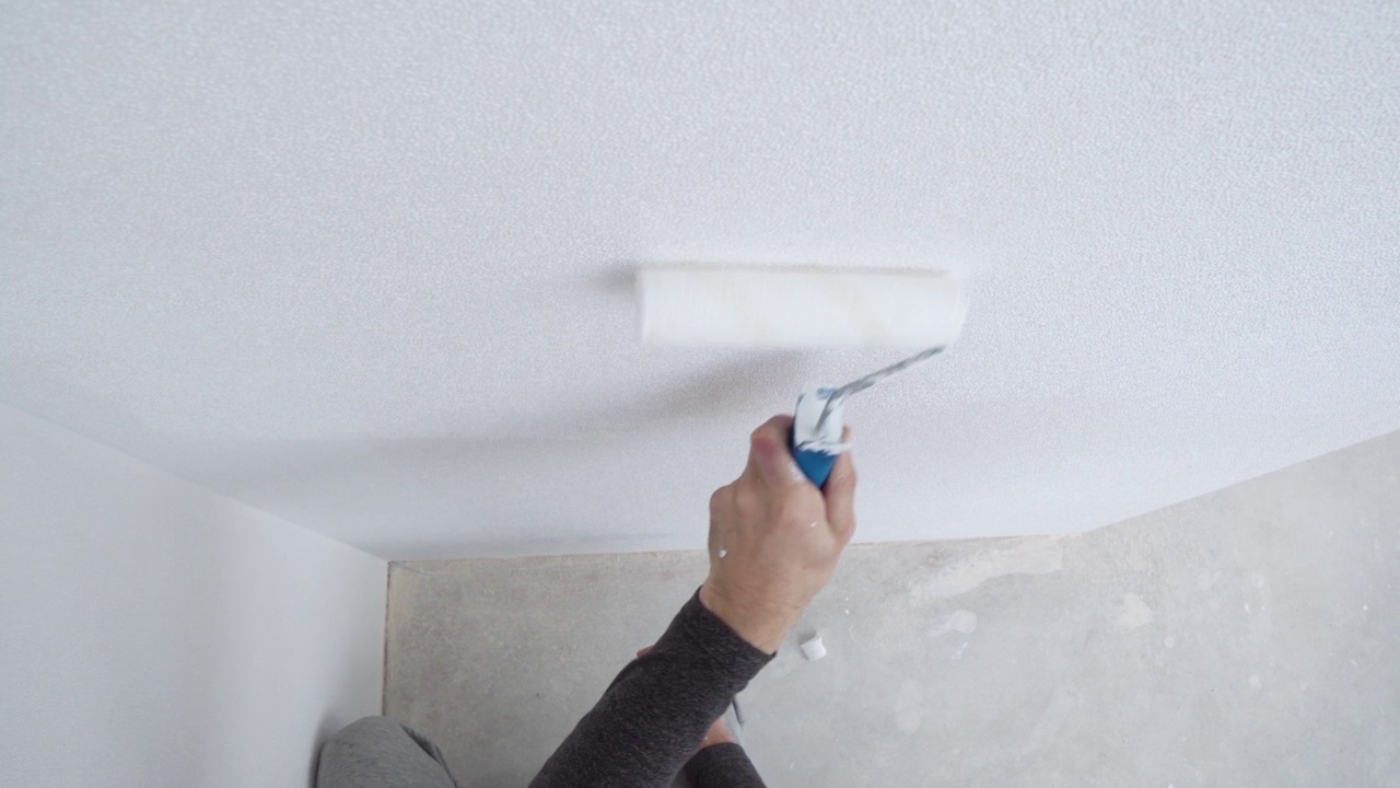 油漆工把新公寓的墙壁刷成白色，专家在工作视频素材