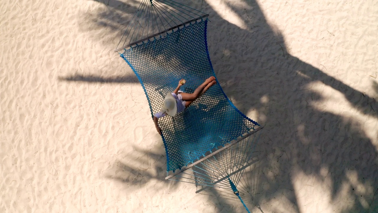 上图是在沙滩上吊床上放松的女人视频素材