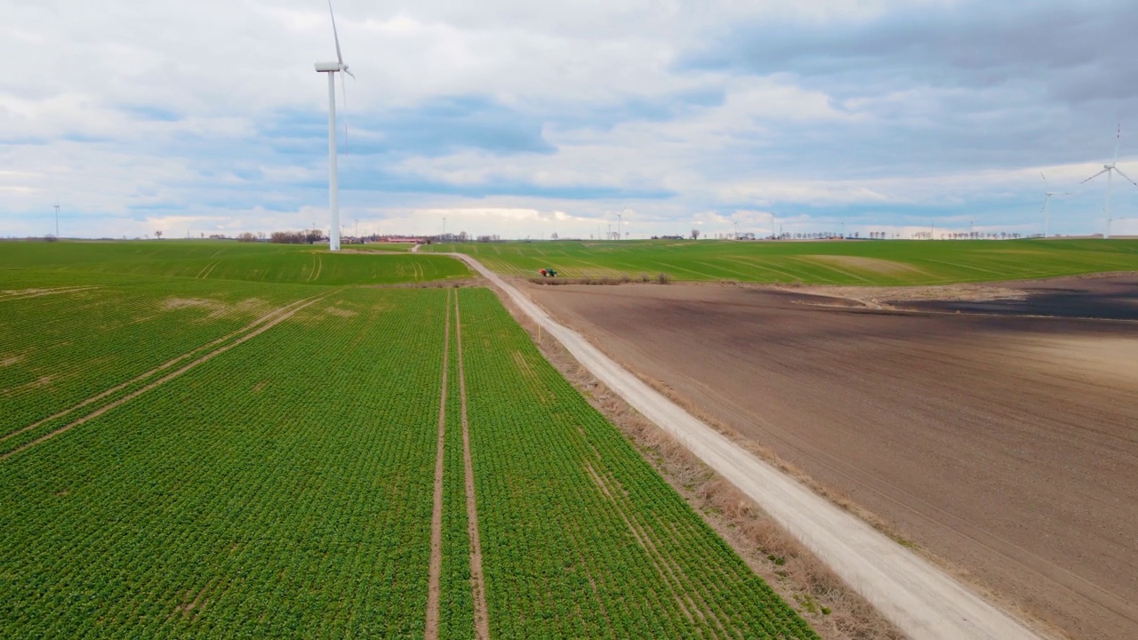 用于产生可再生绿色生态能源的大型风力涡轮机和农用拖拉机视频素材