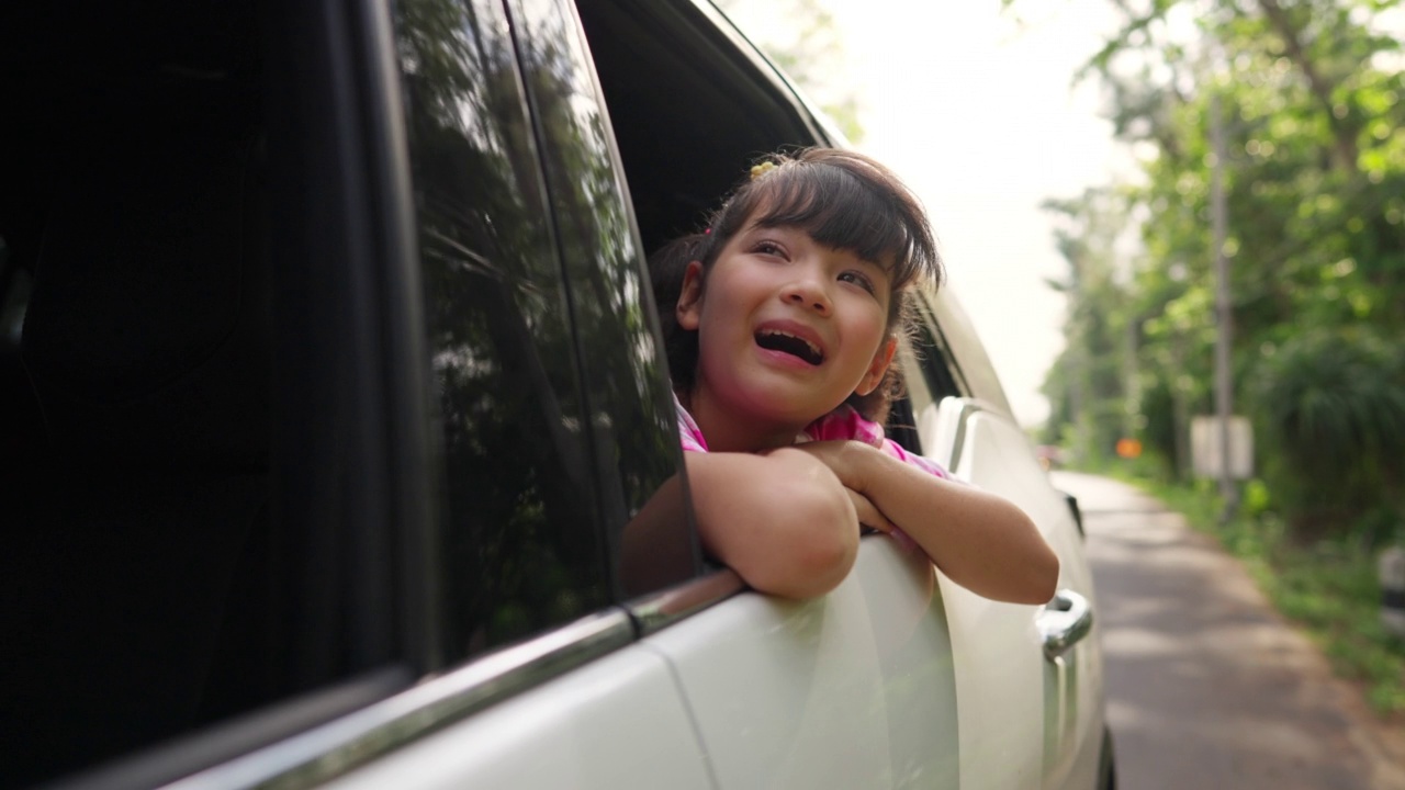 幸福的亚洲小女孩享受和家人在车在夏天的自驾游假期。视频素材