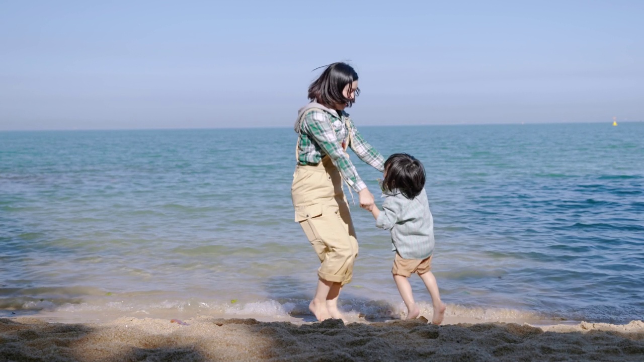 亚洲家庭正在愉快地在海滩上戏谑度假的放松，家庭关系的概念，旅行，放松。视频素材