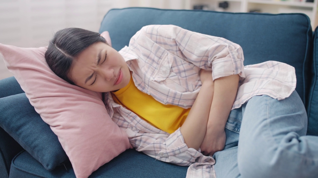 女人躺在沙发上，痛经，痛经，子宫内膜异位症视频素材