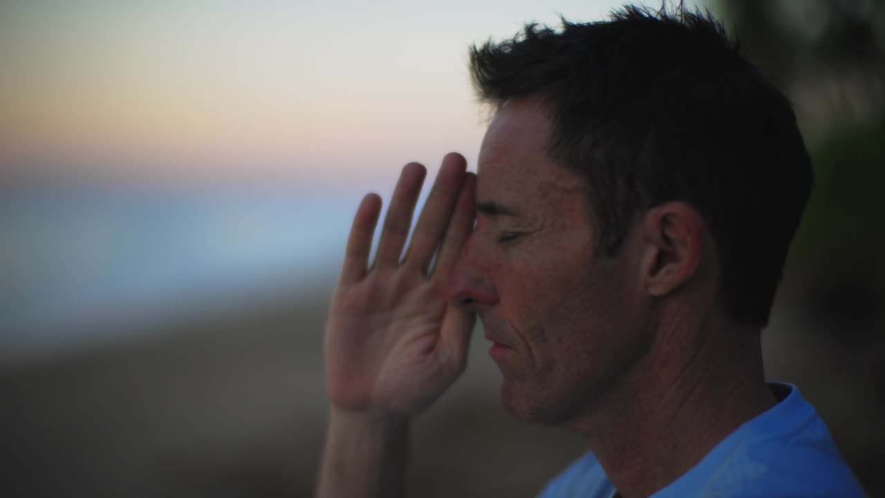 SLO莫。铜。男子在沙滩上做昆达里尼瑜伽的侧面视图视频素材