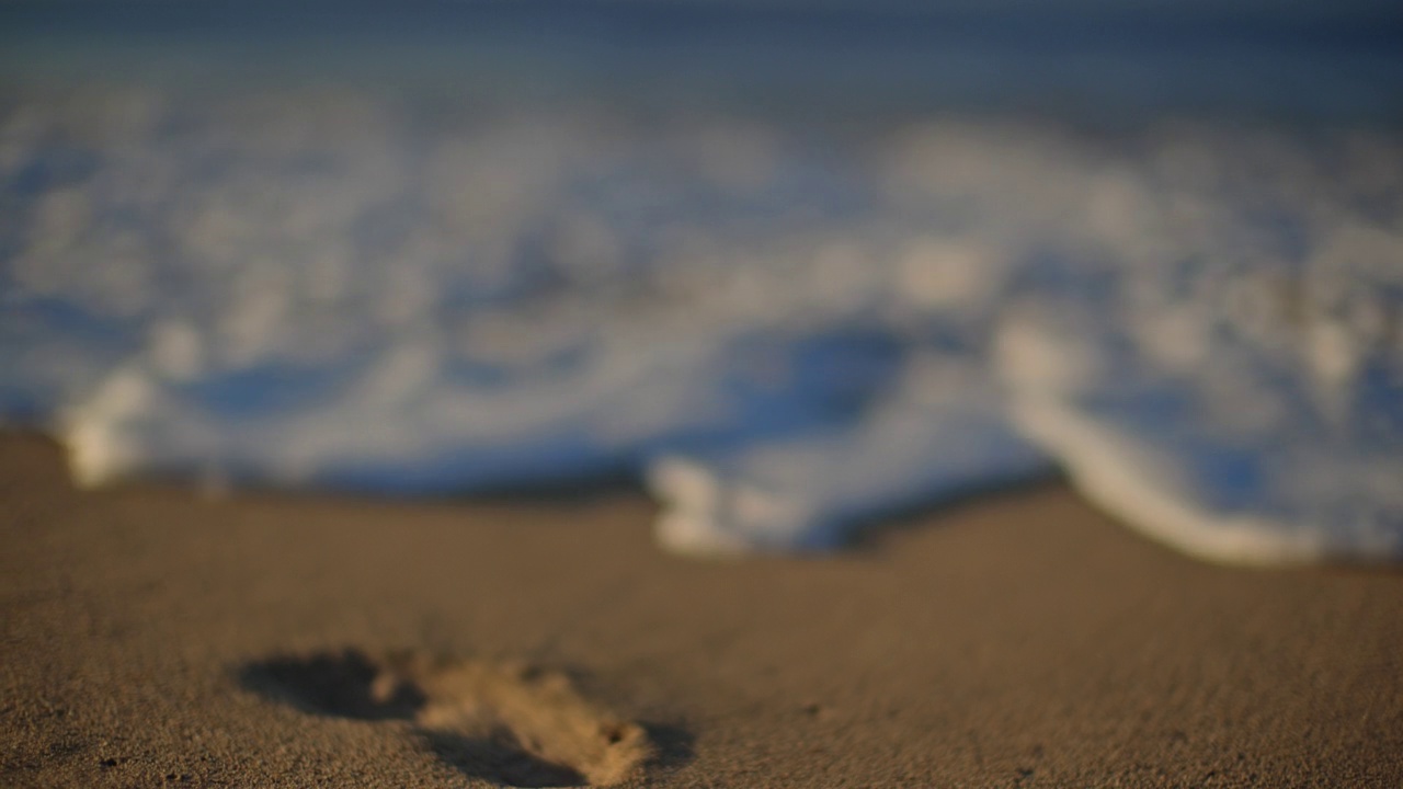 SLO莫。铜。海浪打破了夏威夷沙滩上的脚印视频下载