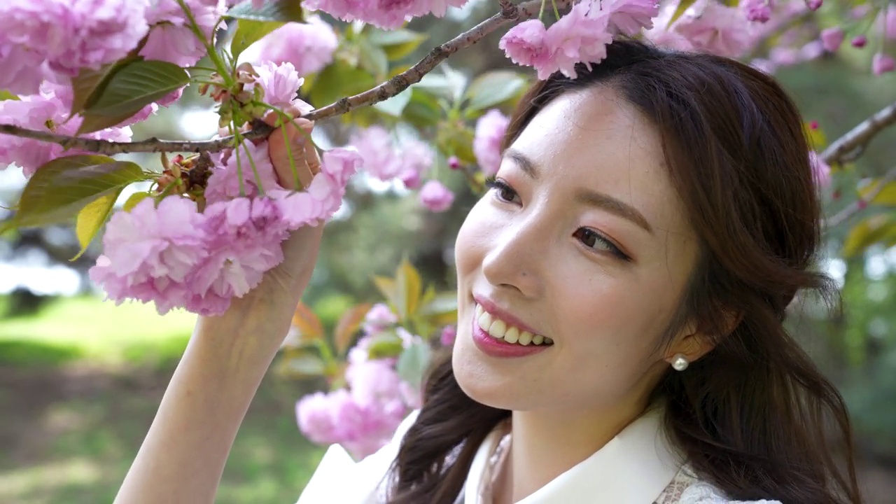 婚礼-年轻的新娘在鲜花下对着镜头微笑/韩国视频下载