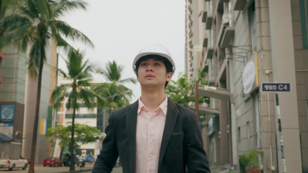 一个机器人工程师戴着帽子和纸工具步行去城市工作。视频素材