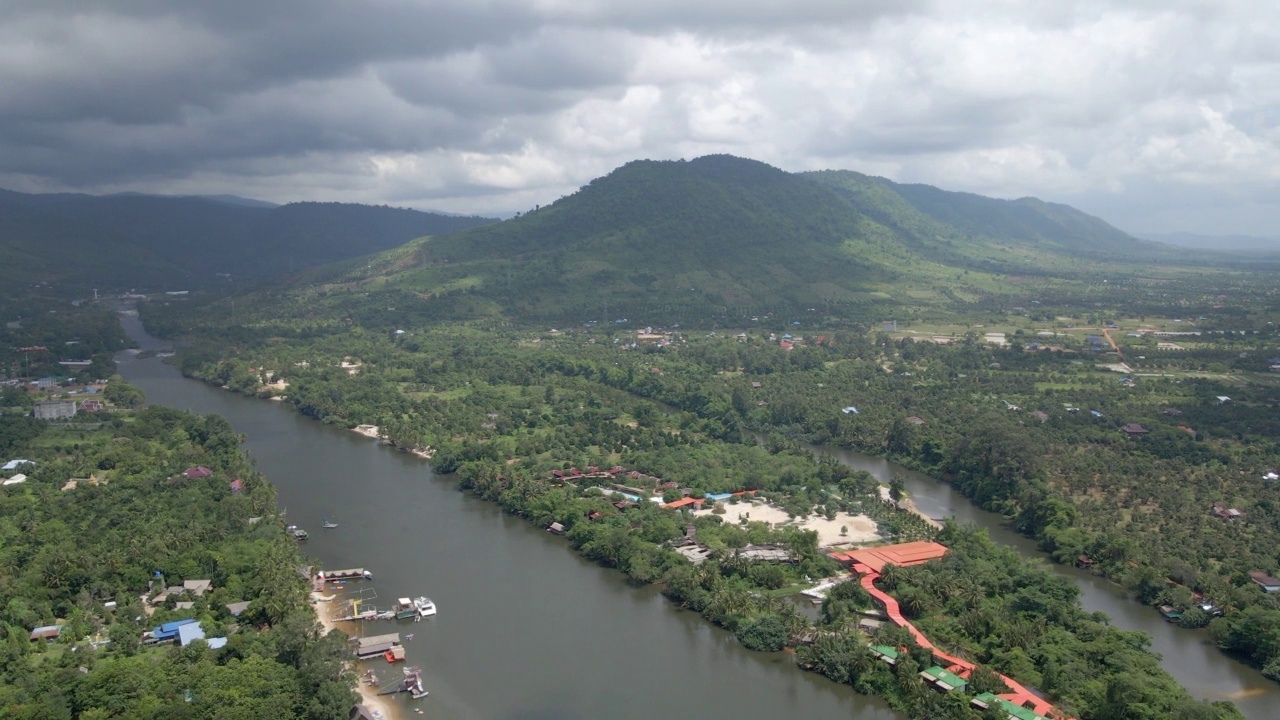 无人机拍摄的Preaek Tuek Chhu河的高角度镜头。背景中山上的雨云视频素材