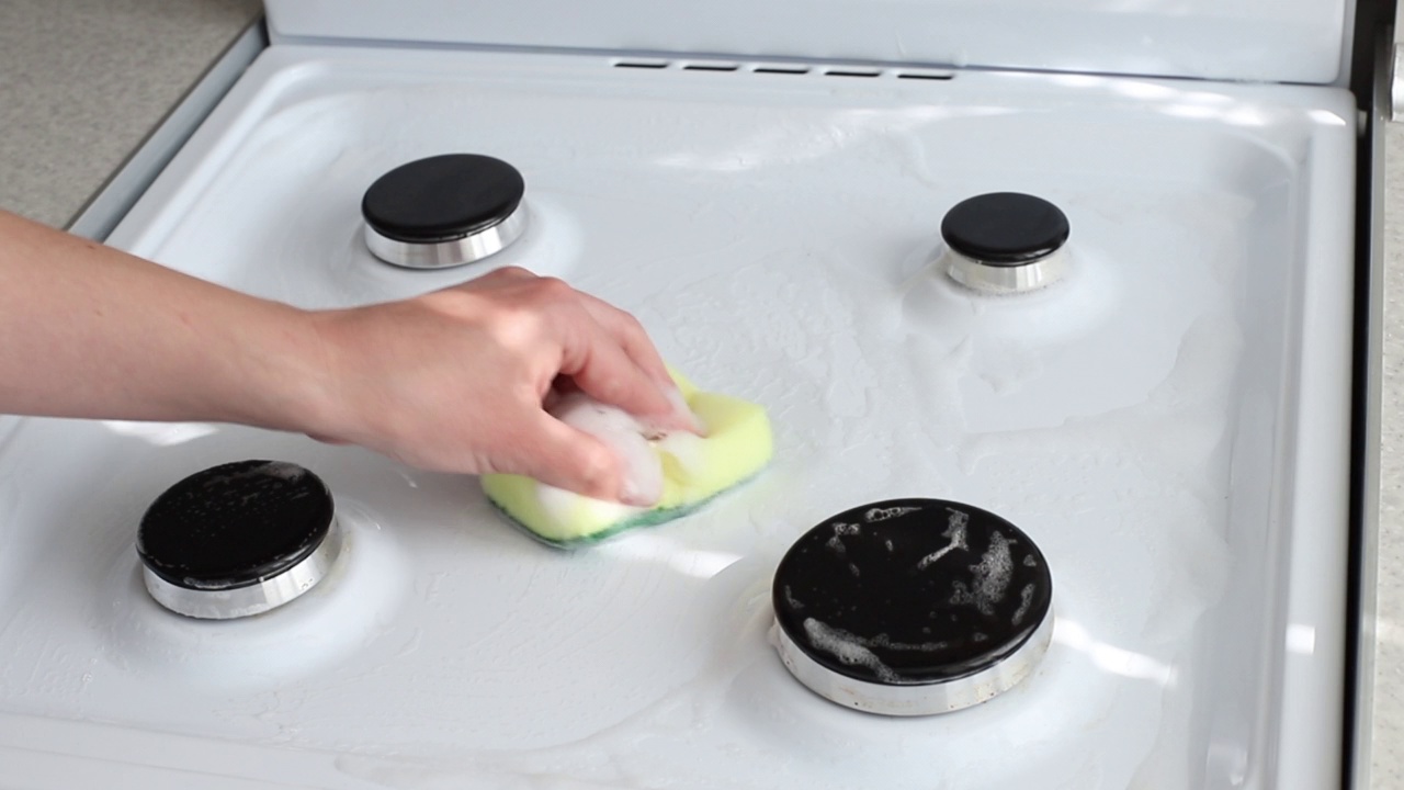 用厨房里有泡沫的海绵清洗炉子视频素材