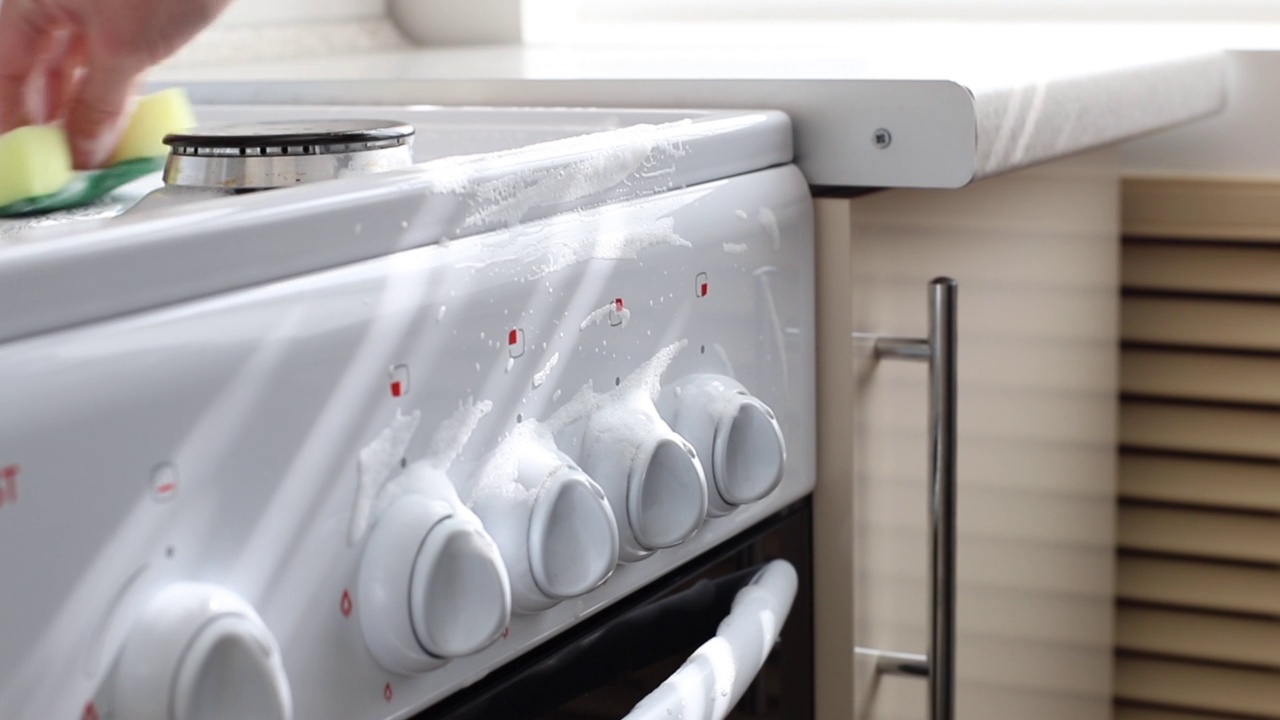 用有泡沫特写的海绵清洗厨房的炉子。清洁服务视频素材