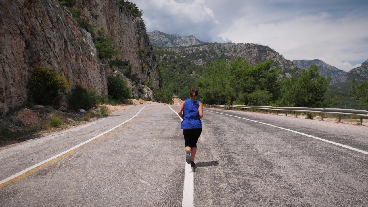 精力充沛的女人在山路上奔跑。确定女性跑步和实现运动健身目标。健身活动和娱乐追求。休闲活动和健康的生活方式。慢跑的概念视频素材