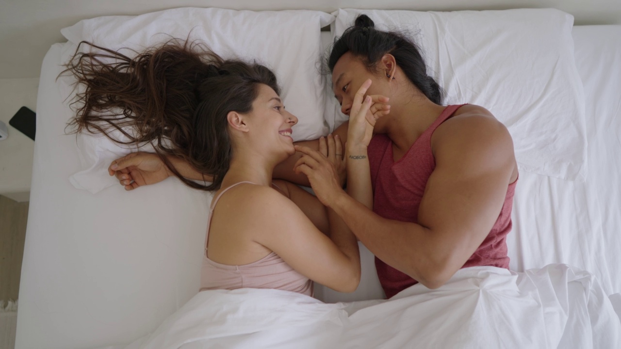 夫妻俩在床上享受慵懒的早晨视频素材