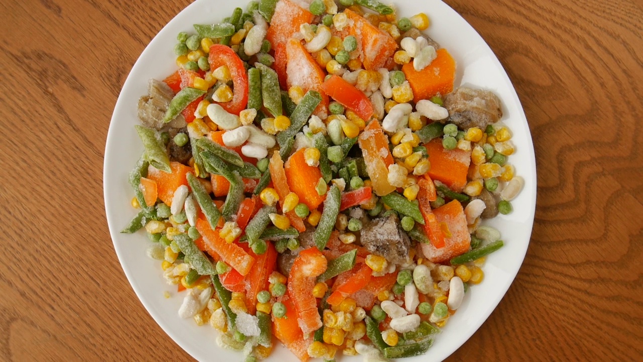 把冷冻蔬菜混合在一个盘子里。视频素材