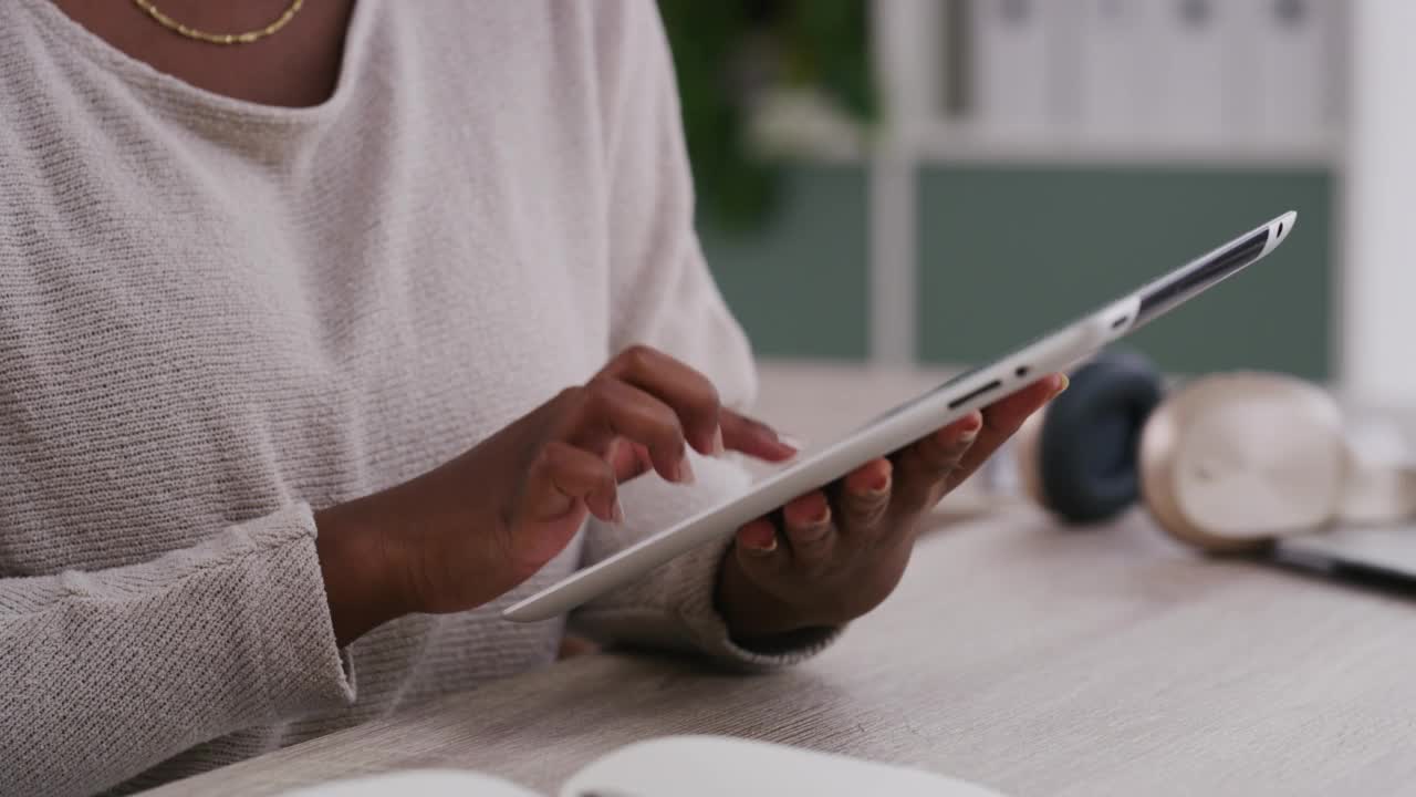 年轻的非洲裔美国女商人在现代办公室独自工作时使用和手持数字平板电脑。一名黑人女商人在工作间隙用数字平板电脑打字。视频素材