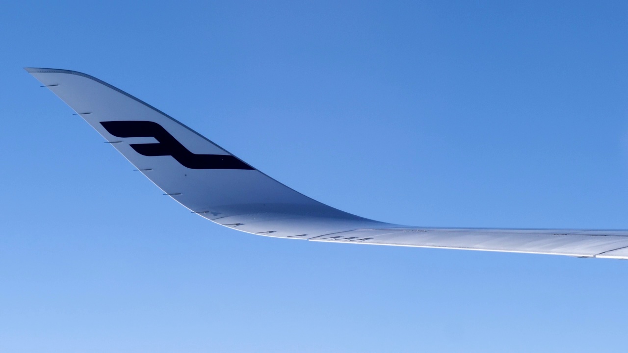 4k飞行镜头看窗外看到芬兰航空A350飞机机翼尖端和美妙的蓝色令人放松的云景从飞机飞行在天空通过云，旅行，航空和交通的概念视频素材