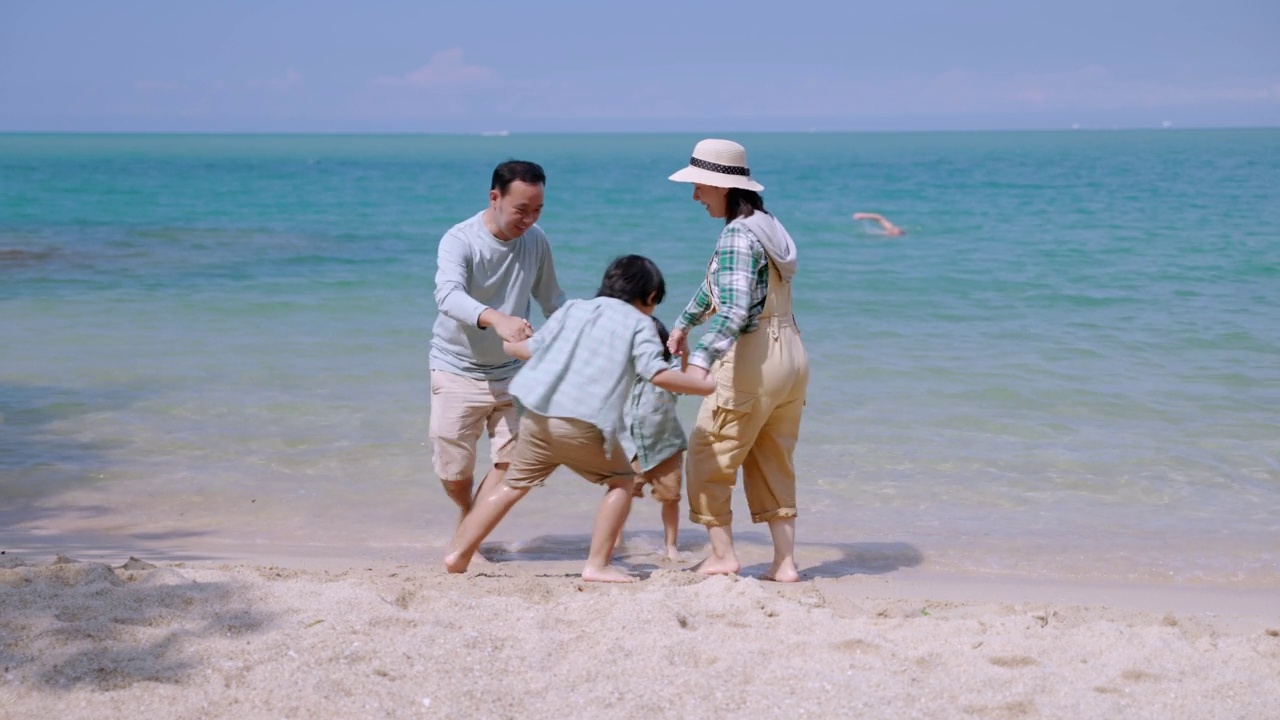 亚洲家庭正在愉快地在海滩上戏谑度假的放松，家庭关系的概念，旅行，放松。视频素材