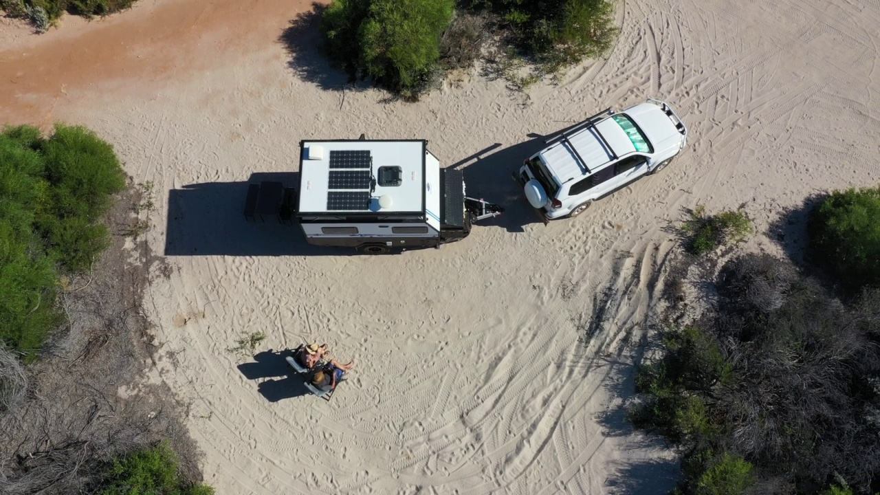 一对澳大利亚夫妇在沙滩度假时开着四轮驱动汽车和大篷车视频下载