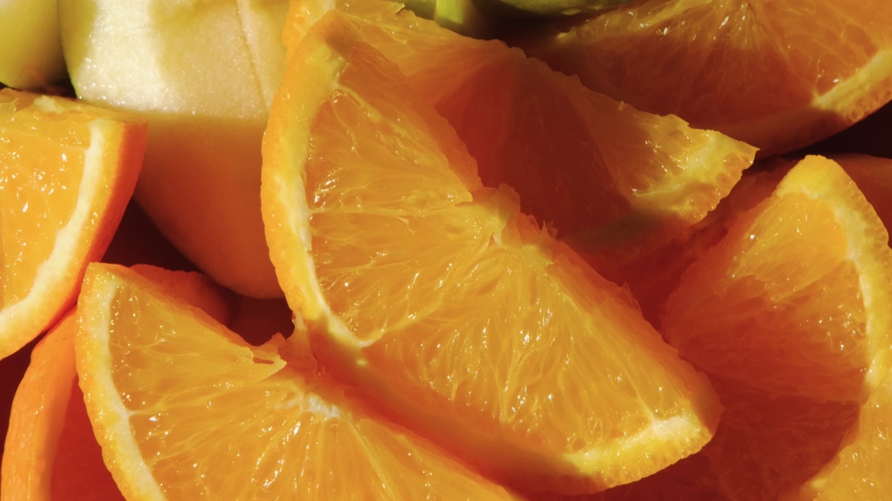 夏季水果盘，新鲜多汁的橙子和苹果切成片。视频下载