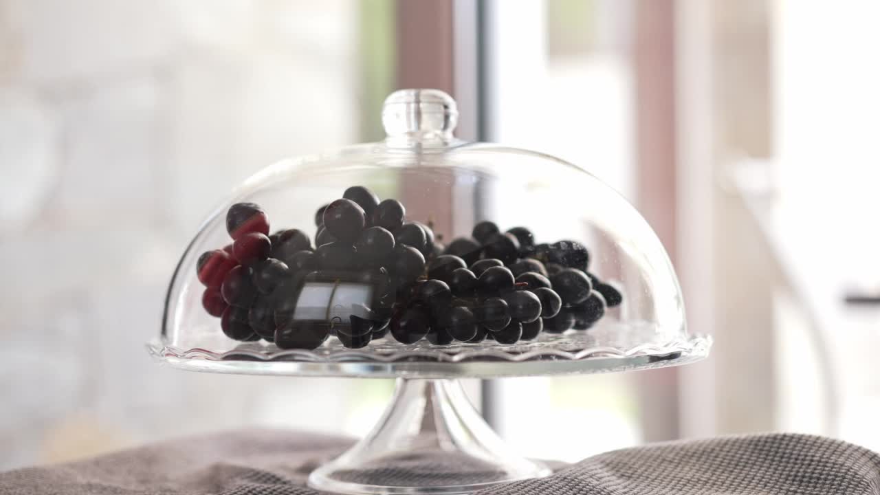 近距离的美味葡萄在透明托盘与女性手采取一个浆果在慢动作离开。美味的有机健康的维生素水果室内。视频下载