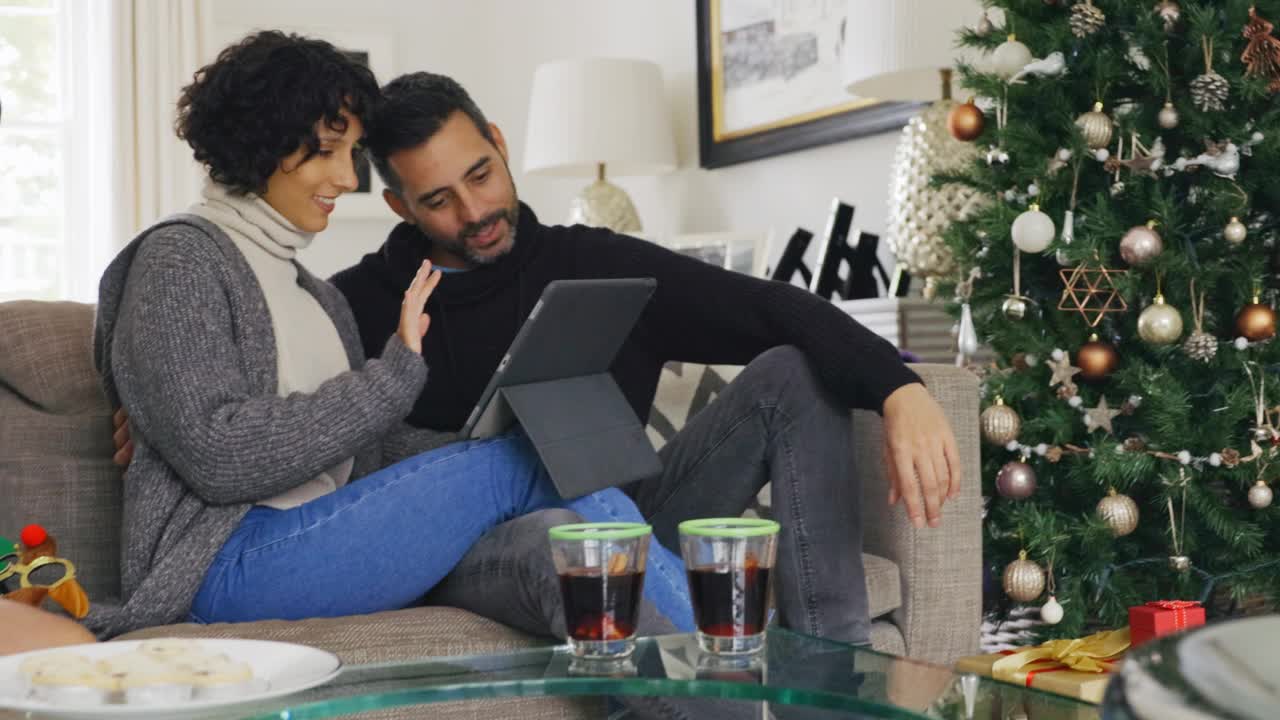 情侣们在圣诞节用平板电脑和亲人视频聊天视频素材
