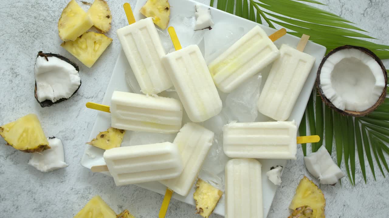 夏天的冰棒在棍子上。Pinacolada味道。由菠萝，牛奶，朗姆酒制成。素食点心视频素材
