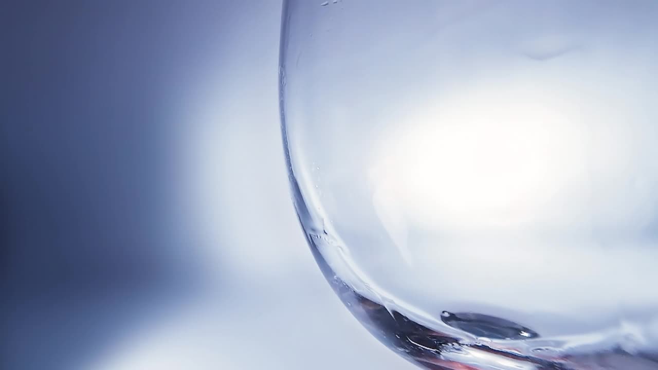 创意宏慢动作4k视频红酒倒入玻璃杯。玻璃杯与倒红酒的特写。用高速电影摄影机拍摄的。视频素材