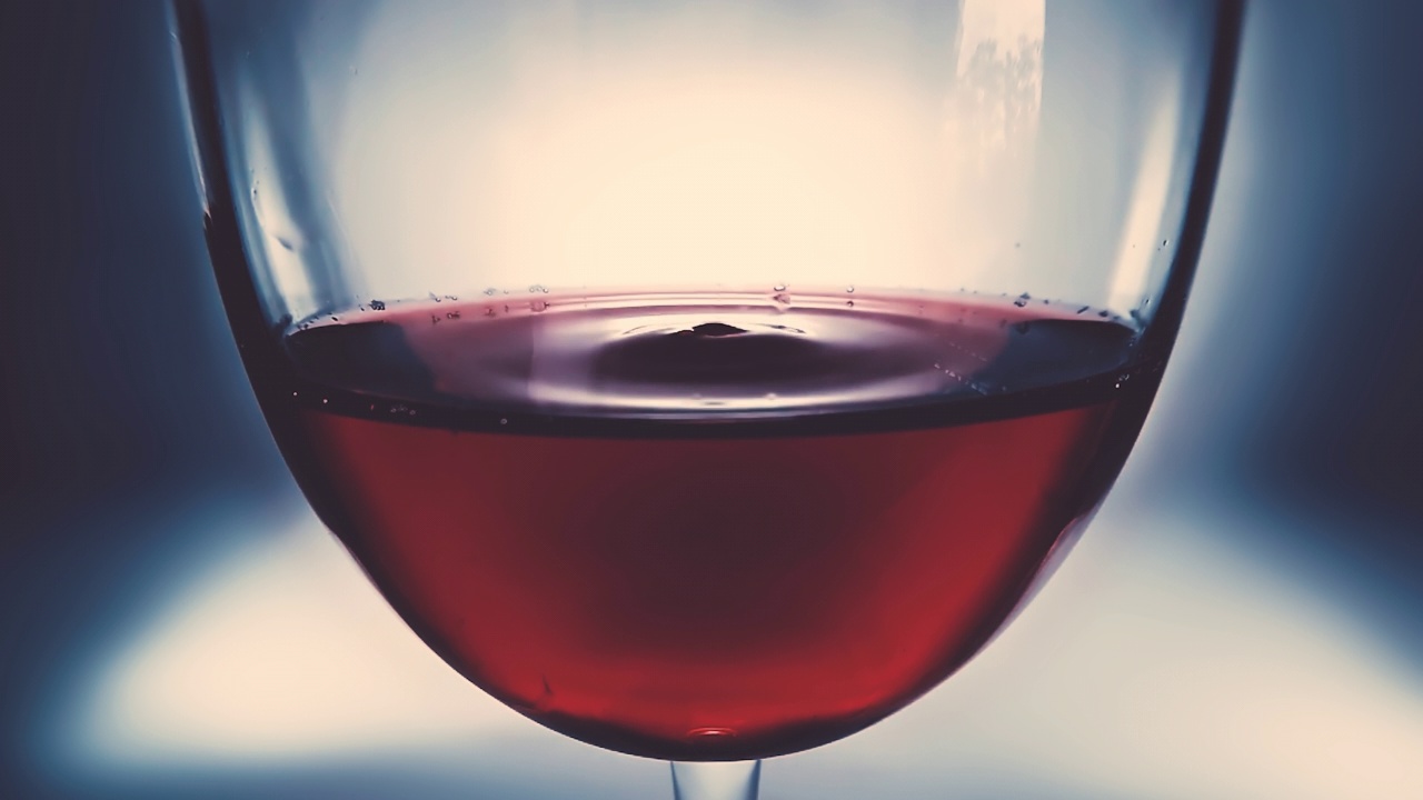 创意宏慢动作4k视频红酒在一杯和下降的葡萄酒滴。缓缓落下的红酒滴在玻璃杯里的特写。用高速电影摄影机拍摄的。视频素材