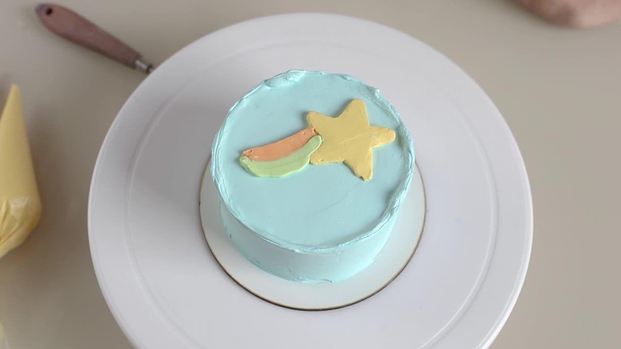 糖果商在圆形蛋糕上用奶油做了一道彩虹，装饰过程的特写视频下载
