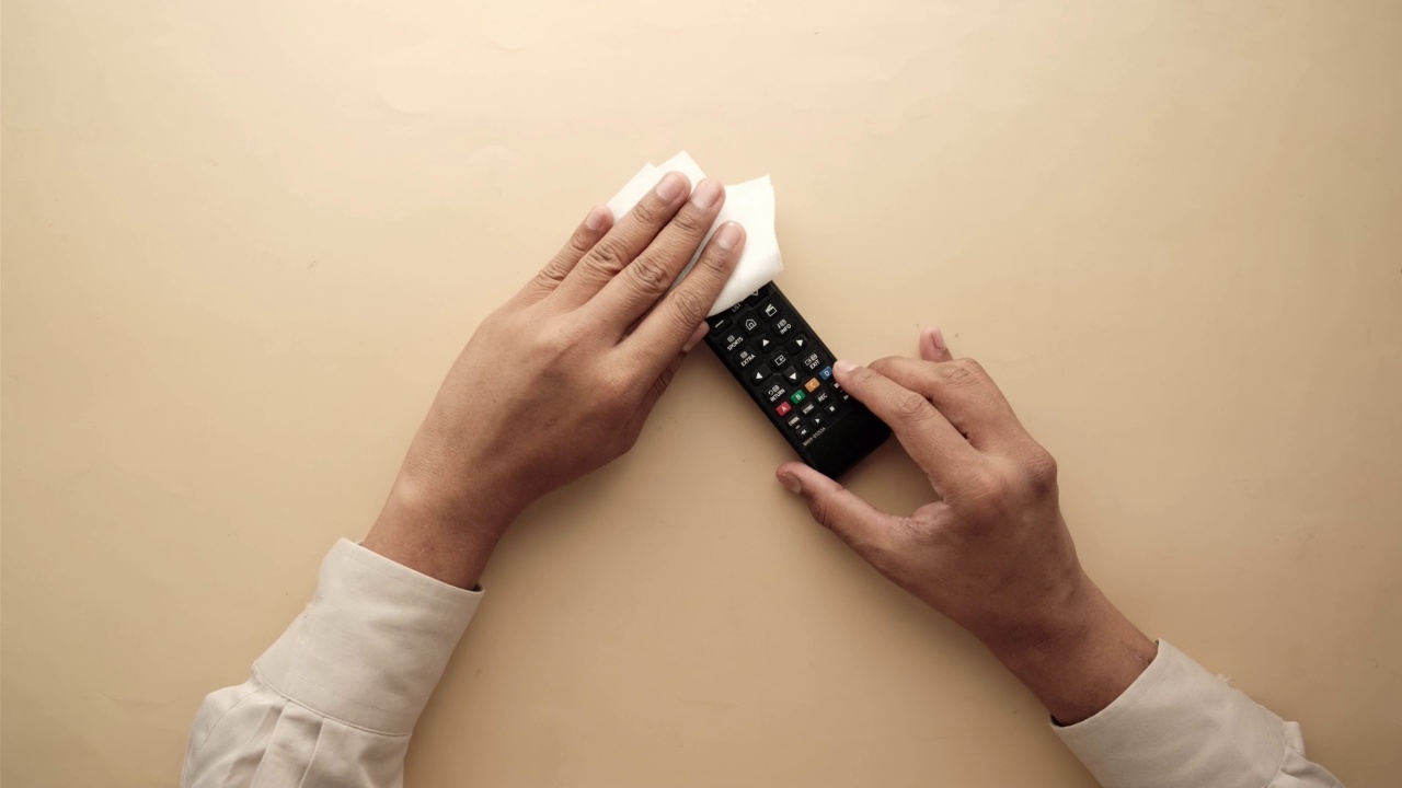 用抗菌织物纸巾清洁电视遥控器。视频下载