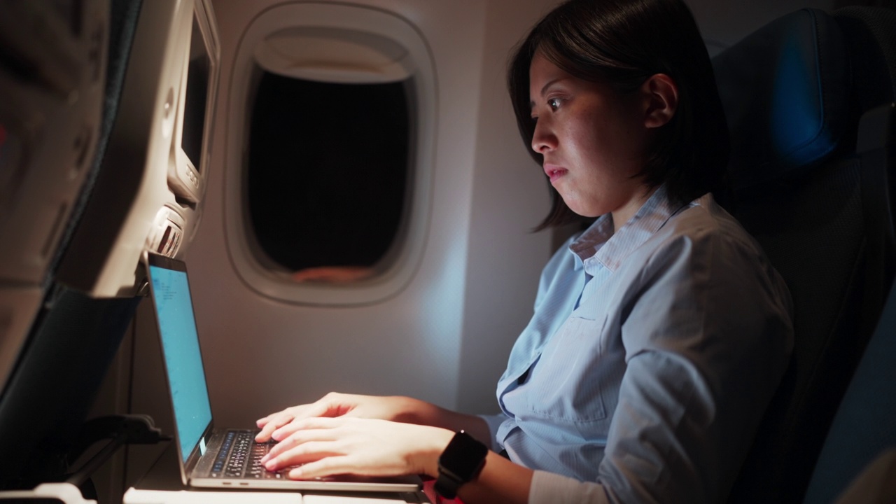 在飞机上用笔记本电脑工作的女商人。商务旅行视频素材