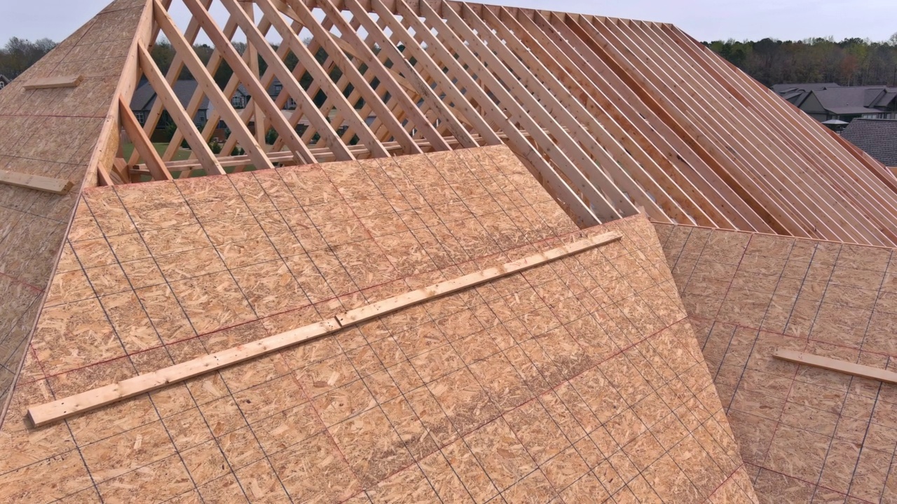 屋顶工人在一个新的屋顶上工作，把木胶合板的顶视图视频素材