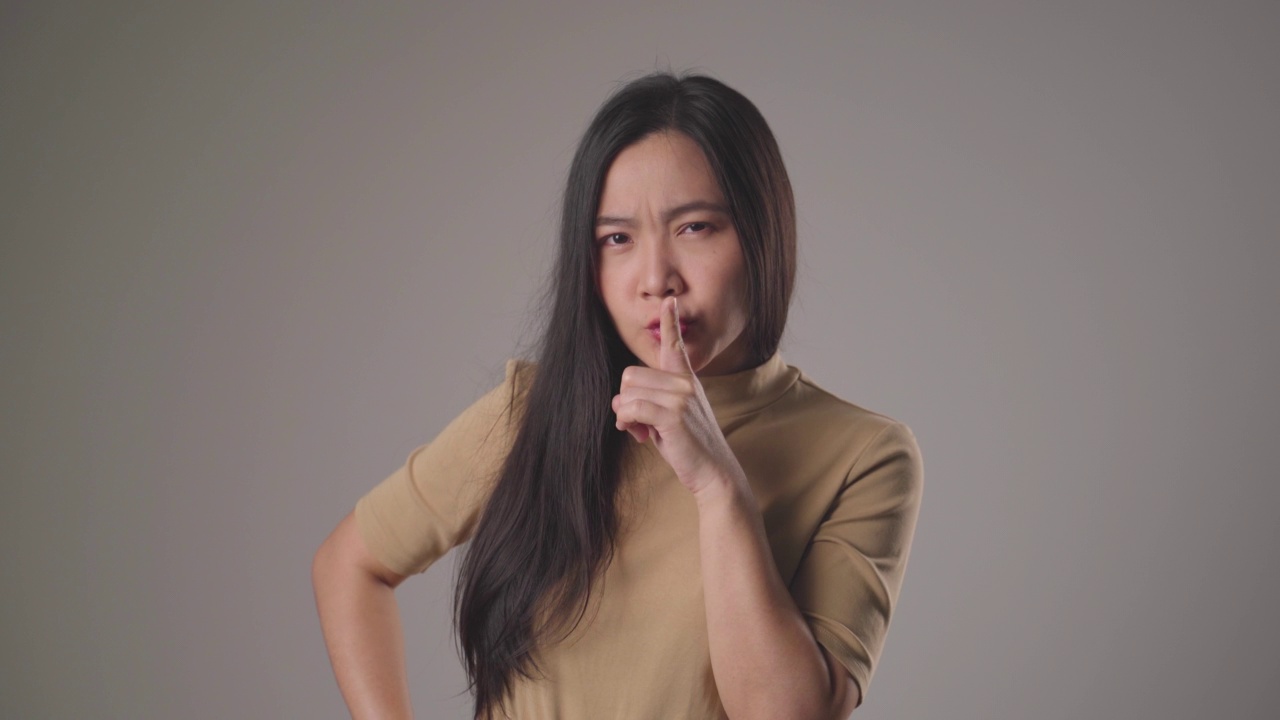 女人把食指放在嘴唇上意味着保守秘密。视频素材