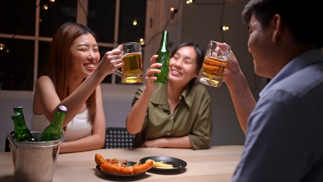 亚洲朋友在庆祝节日，他们碰杯啤酒视频素材