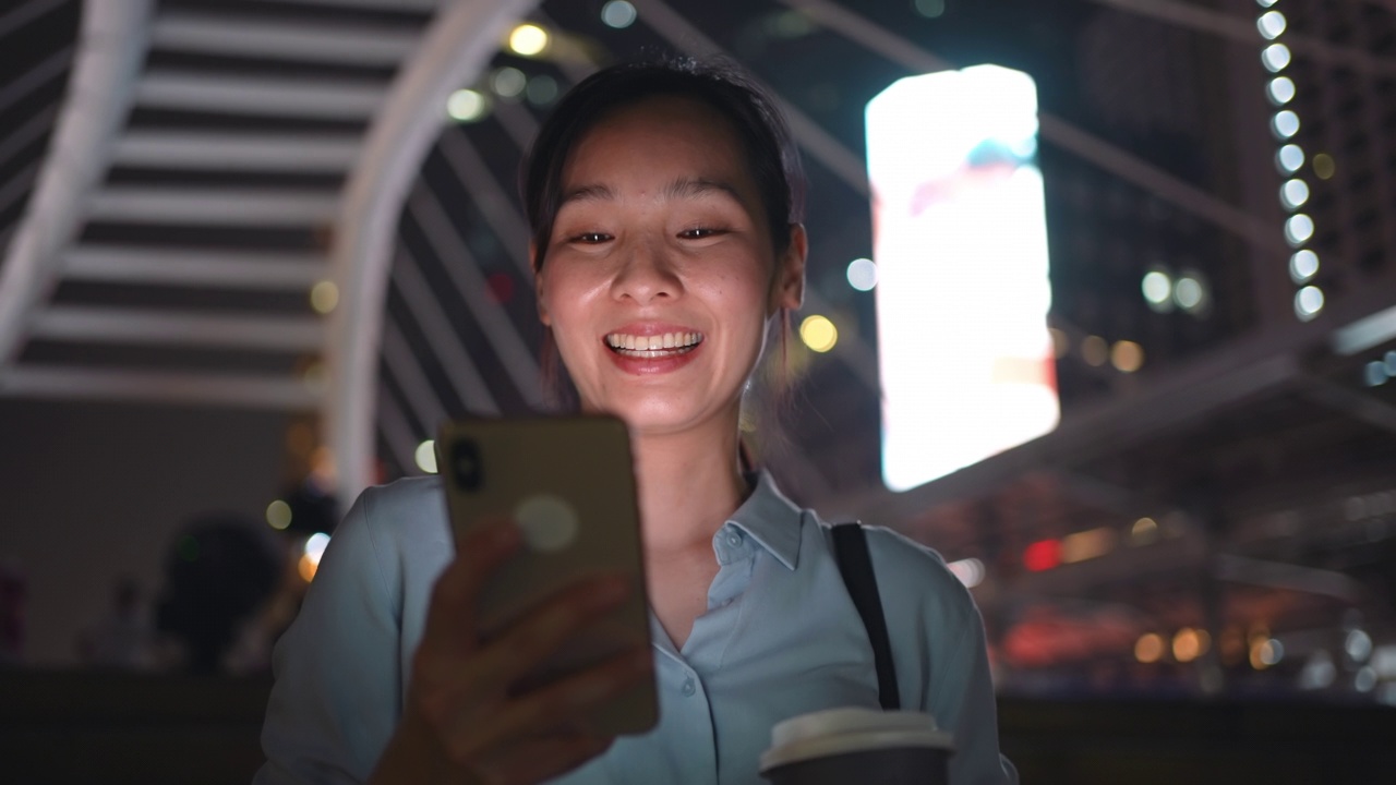女人在夜晚使用智能手机视频素材