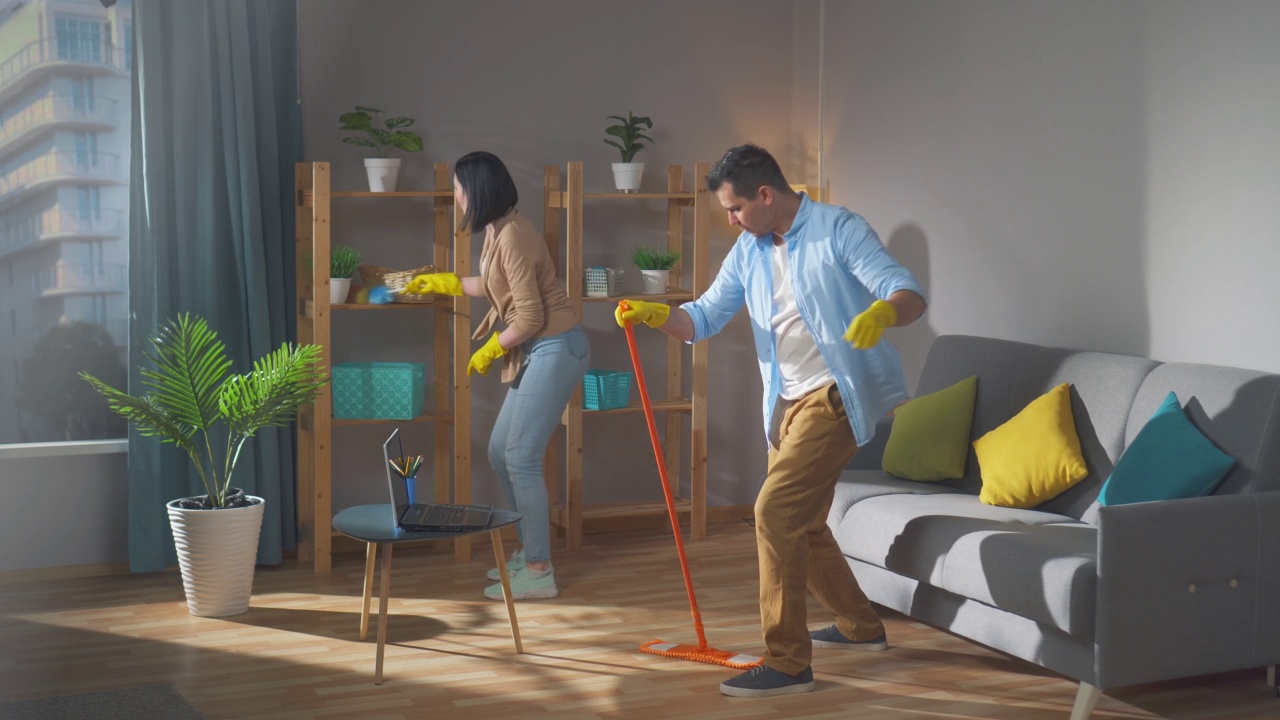 积极的夫妻正在打扫房子，跳舞，唱歌视频下载