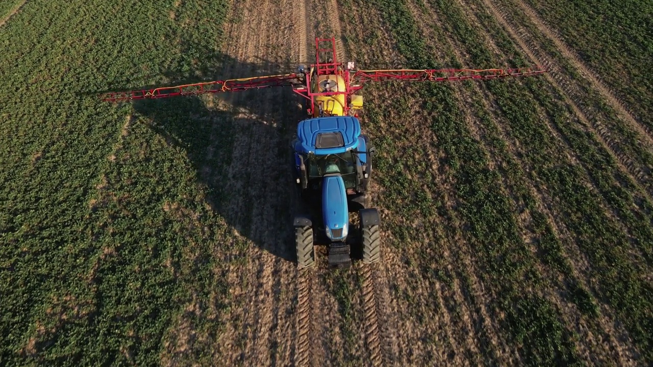 拖拉机在农田上喷洒化肥，鸟瞰图视频素材